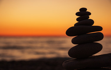 The object of the stones on the beach at sunset. Zen concept. Sunset. Silhouette of stones against the sunset sky