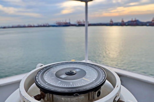 View of the ship and piers on the background of the magnetic compass card.