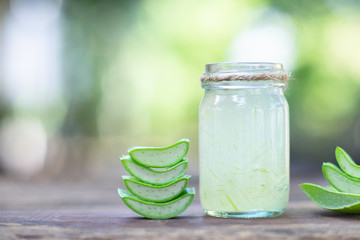 Fresh aloe vera stem slices and gel on wooden table, skin therapy concept