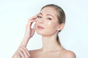 portrait of a young beautiful woman with drawn massage lines on her face. skin lifting concept....