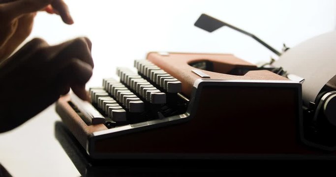Close up of writer's hands prints on vintage typewriter. Typing on old typewriter. Woman's hand typing on retro machine. The writer's hands on a typewriter begin to write