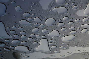 Wassertropfen liegen auf einer getönten Glasscheibe