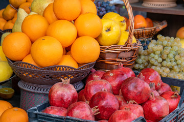 Street side shop selling fruits pomegranates, oranges, grapes and others.