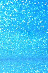 Vertical blue glitter background with blur and bokeh