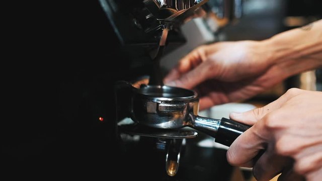Closeup of barista grinding coffee