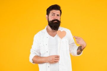 I will be your Valentine. Romantic greeting. man with beard and mustache yellow wall . Handmade heart for holiday. brutal hipster valentine heart. Valentine day party. bearded man ready for love date