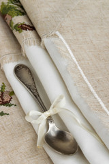 Vintage russian silverspoon with silk ribbon on linen napkin. Old fashion heroloom silverware