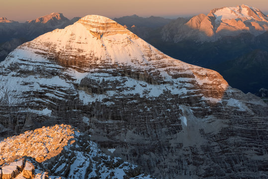 Dawn from the top of Tofana di Mezzo (3244 m) towards Tofana di Rozes after a slight summer snowfall, in the background the Marmolada glacier, Cortina d'Ampezzo, dolomites, Italy