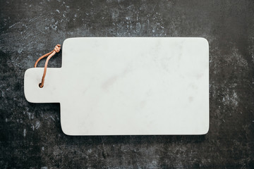 Top down view on an empty white marble cutting board.