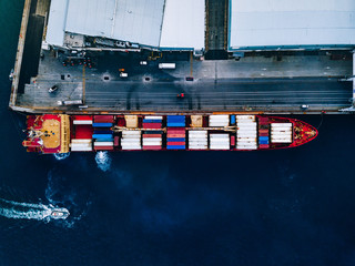 Aerial top view of industrial cargo container ship in terminal in Italy