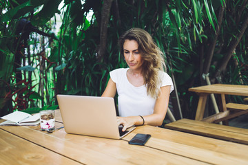 Dissatisfied female working on laptop on terrace