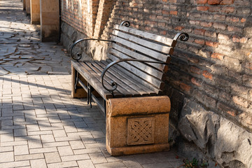 Bench in the park near the brick fence.