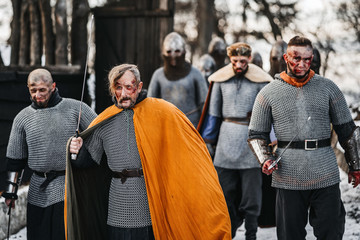 Photo of knights in armor with swords during the war. Evil emotions of a warrior who goes to battle...