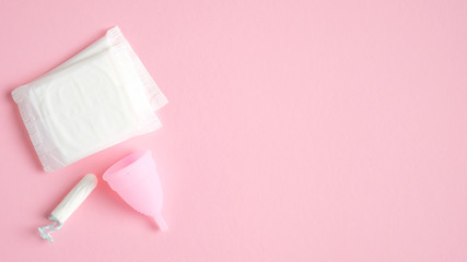 Menstrual hygiene products top view. Flat lay menstrual cup, sanitary pads, tampon on pink background with copy space. Women health care concept. - obrazy, fototapety, plakaty