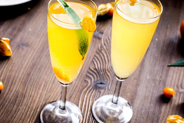 cocktail with physalis in glass on wooden background