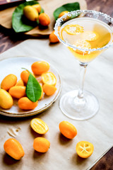 cocktail with kumquat on wooden background