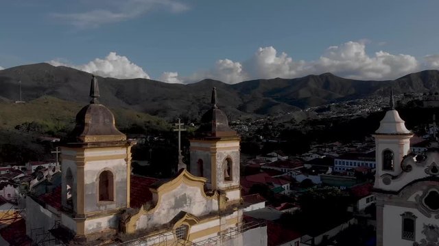 Aerial view of the bell towers of the two churches at central historical Gomes Freire square in the colonial mining town of Mariana in Minas Gerais, Brazil, with rest of the valley in the background