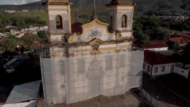 Sunset aerial ascending tilt view of the San Francisco church at central historical Gomes Freire square in the colonial mining town of Mariana in Minas Gerais, Brazil, wrapped as part of renovations