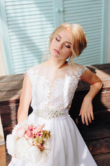 portrait of a beautiful girl with blue eyes and white hair with a bouquet of flowers and a white dress