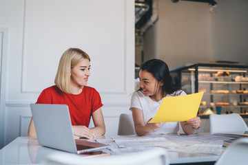 Laughing young freelancers working with documents