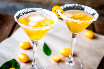 cocktail with kumquat on wooden background