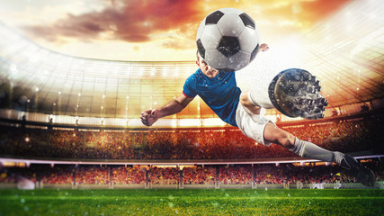 Soccer striker hits the ball with an acrobatic kick in the air at the stadium at sunset