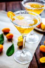 cocktail with kumquat on wooden background