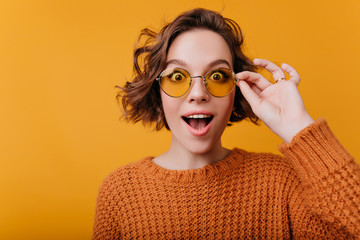 Close-up portrait of pale girl with wavy hairstyle expressing true amazement. Surprised woman in...