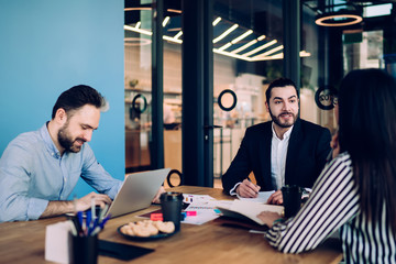 Adult businessman giving instructions for employee during meeting in office