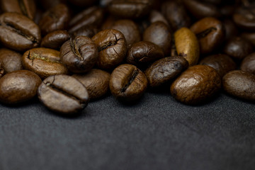 Coffee in beans on dark background. Abstract background texture.Coffee beans texture. Food background of coffee beans