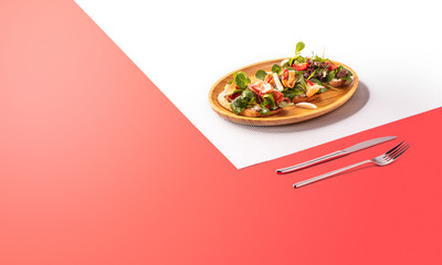 Croutons with Salmon, tomatoes and spinach. Colorful sunny background. Tasty menu for european food.