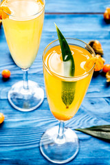 cocktail with physalis in glass on wooden background