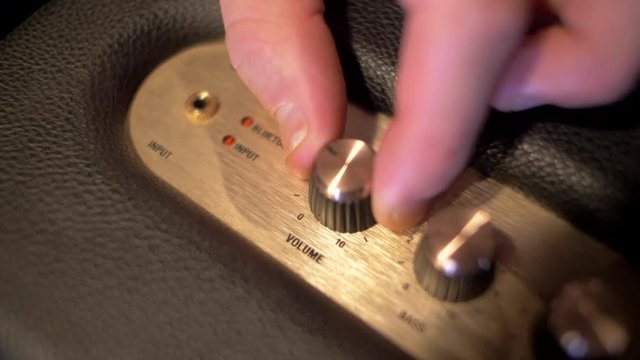 Man turning up volume music on speaker