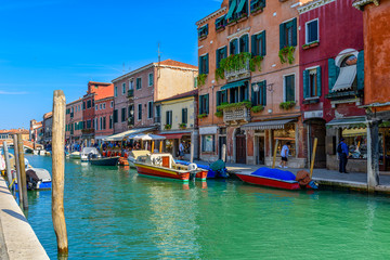 Naklejka na ściany i meble Canal with old buildings and boats in Murano island, Venice, Italy. Architecture and landmarks of Venice. Venice postcard