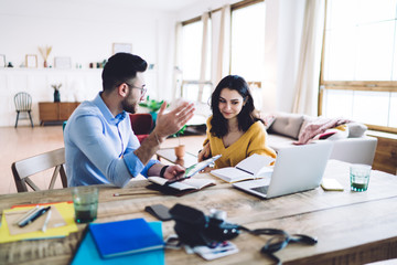 Obraz premium Focused couple taking notes and using gadgets