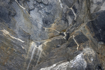 moss grows in rocky cracks and layers of mountain formation are visible