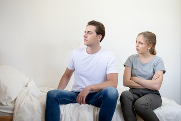 Caucasian man and woman have argument sit on bed in bedroom,Conflict violent and annoyed couple with unhappy relationship.