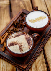 Two cups of cappuccino coffee with latte art on woden table background