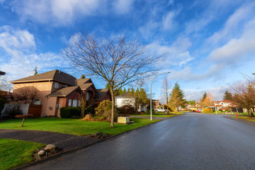 Fototapeta na wymiar Residential Suburban Neighborhood in the City during a vibrant winter sunrise. Taken in Fraser Heights, Surrey, Vancouver, BC, Canada. Wide Angle