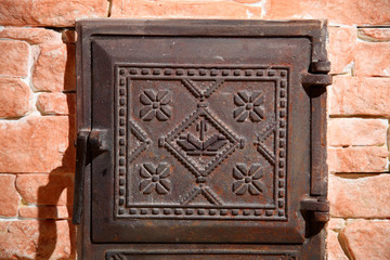 Wrought iron door of the stove with a national Ukrainian ornament. Iron door of the stove. Two old furnace doors. Ancient stove. Cast iron door for furnaces. Iron door ornament.