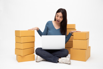 Happy young asian woman startup small business freelance with computer laptop and sitting on floor isolated on white background, Online marketing packing box delivery concept