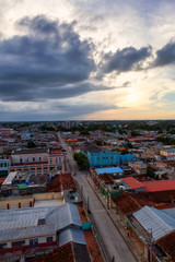 Obraz premium Ciego de Avila, Cuba - June 14, 2019: Aerial view of a small Cuban Town during a cloudy and colorful sunset.