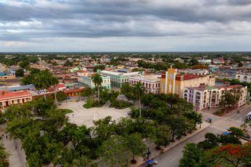 Fototapeta na wymiar Ciego de Avila, Cuba - June 14, 2019: Aerial Panoramic view of a small Cuban Town during a cloudy and colorful sunset.