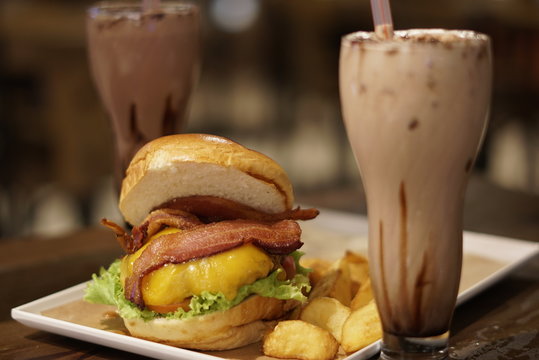 Bacon burger with beef patty on wooden table
