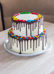 White Birthday cake with colorful Sprinkles over a light background