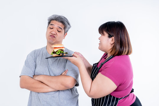 Portrait images of Asian wife Obese persuading her husband To eat a hamburger That she prepared On white background, concept to Asian family and fastfood