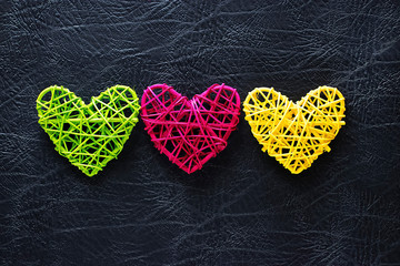 Three multi-colored hearts on a gray background. Valentine's day concept.