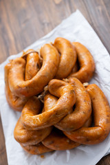 portuguese smoked sausages alheira on white paper on ceramic background