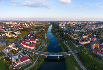 Panoramic view of the city of Grodno, the embankment, the Neman river and the old city. Autumn evening, the city in the sunshine against a background of dark clouds and a rainbow.
