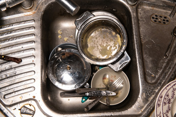Dirty dishes pile up in sink